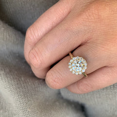 This one-of-a-kind ring starts out with a round brilliant cut all-natural diamond center, and is crowned with a totally custom made floral-inspired diamond and gold halo. An eyecatching choice for a totally unique bride