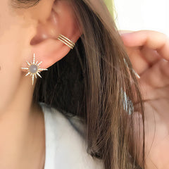 three row ear cuff worn as an accent piece with a larger colored stone stud
