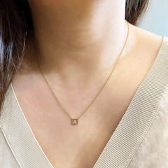Petite initial plaque necklace being worn