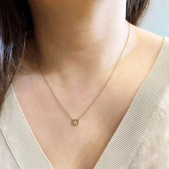 Petite initial plaque necklace being worn