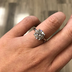 a simple showstopper, this gorgeous hand selected round diamond sits atop a knife edge band with 4 prongs. A classic beauty for a modern or traditional bride