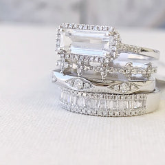 east-west emerald cut colored stone rings in a stack