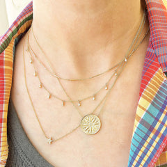a layered necklace look with motifs, textures, colors and movement