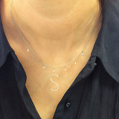 skinny initial necklace being worn with a cascading marquise necklace