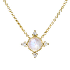 rose cut colored stone in a gold polished bezel with diamonds at the compass points