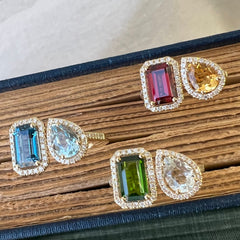 two gemstone toi et moi rings in blues, greens and fire tones