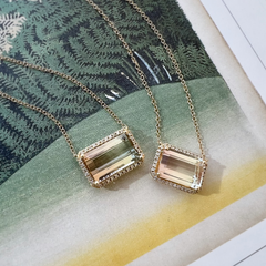 14k yellow gold one of a kind tourmaline necklaces with natural diamonds on a book