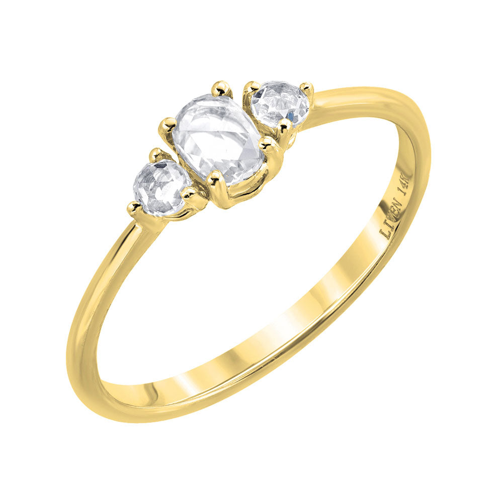 three rose cut diamonds on a yellow gold band. Center stone is oval, and 2 round side stones