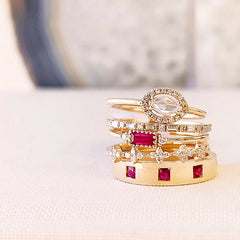 goregously rich stack of rose gold rings with rose cut diamonds, baguette and round diamonds, and rubies