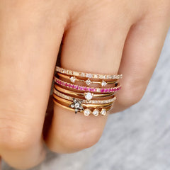 baguette and round halfway band capping off a stack of liven rings