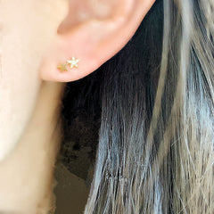 double star post earrings with diamonds on ear