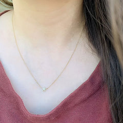 micropave diamond and gold star necklace  being worn alone as a minimalist statement