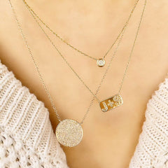single bezel set diamond solitaire necklace layered with other liven pieces