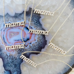 mama necklaces in yellow gold on an agate slice background