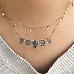 the cascade necklace layered with a pear shaped colored stone necklace