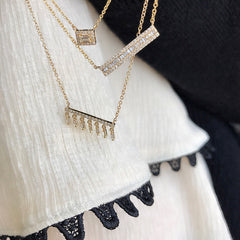 petite baguette halo necklace layered with other liven necklaces