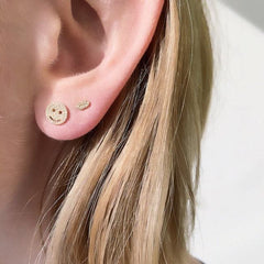 smiley face post earring on ear