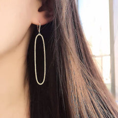 open elongated oval earrings on ear