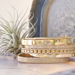 collection of classic bangles and cuffs with gold and diamonds