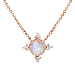 rose cut colored stone in a gold polished bezel with diamonds at the compass points
