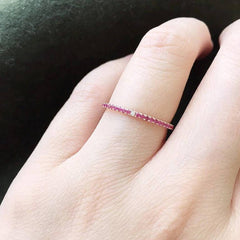 Ruby eternity band with diamonds at compass points on hand