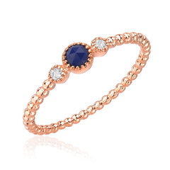 lapis lazouli center stone bracketed with diamonds on a 14k gold beaded band