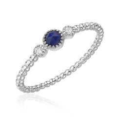 lapis lazouli center stone bracketed with diamonds on a 14k gold beaded band